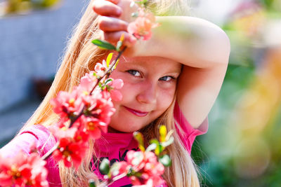 Portrait of cute smiling girl holding flowers in park