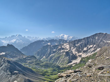 Aerial view of snowcapped mountains against clear blue sky