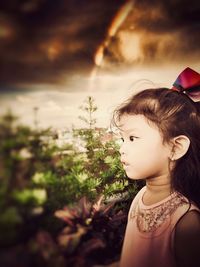 Portrait of girl looking away against sky