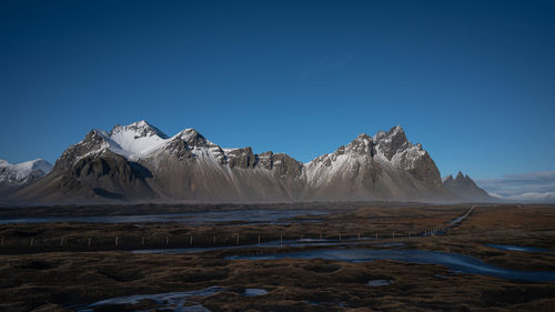 Scenic view of mountains against clear blue sky