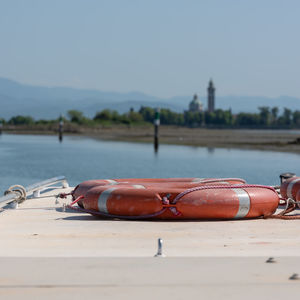 Close-up of rope on table by river against sky