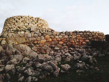 Stack of rocks on field against sky