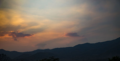 Scenic view of silhouette mountains against sky at sunset