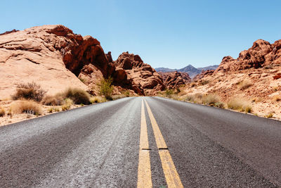 Road amidst rocks against sky