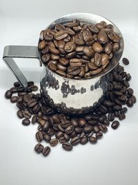 Close-up of coffee beans on table against white background