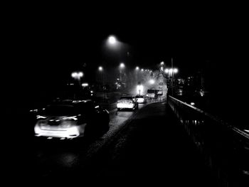 Cars on illuminated street at night