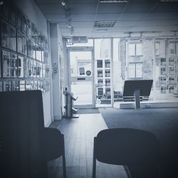 Empty chairs and table against window