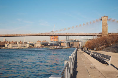 Bridges over east river and promenade against clear blue sky