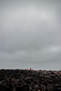Person on rock against sky