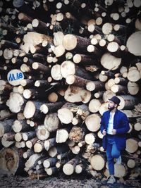 Full frame shot of man leaning against logs