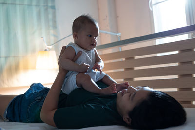 Mother playing with cute girl at home