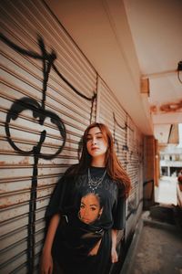 Portrait of woman standing against wall