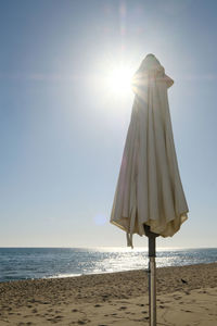 Lifeguard hut on beach against sky on sunny day