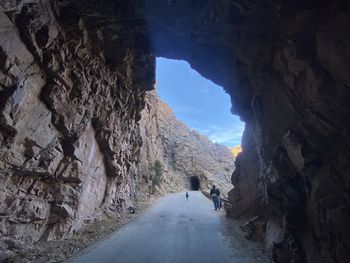 Rear view of people walking on rock