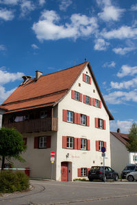 Residential building by road against sky