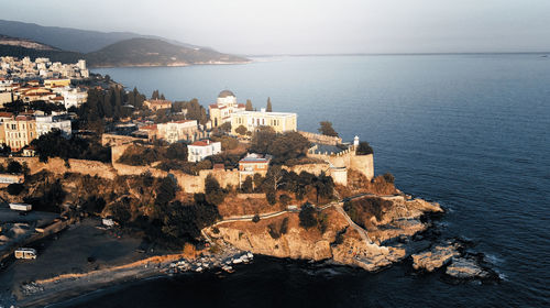 High angle view of townscape by sea against sky