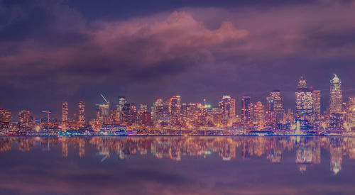 Illuminated buildings in city against sky at night