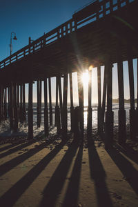 Silhouette pier at beach during sunset