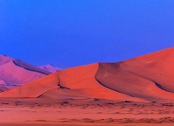 Scenic view of desert against clear blue sky