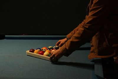 Midsection of man playing pool