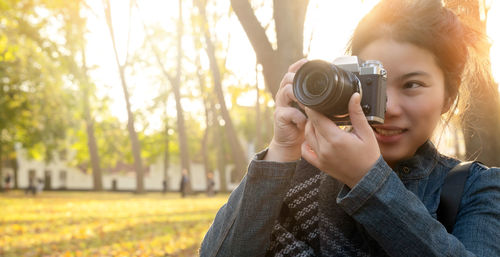 Portrait of smiling woman holding camera