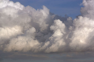 Low angle view of sunlight streaming through clouds