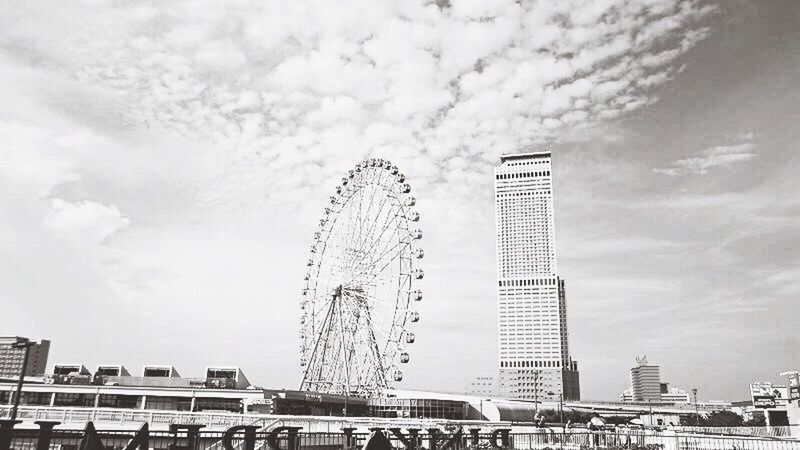 architecture, built structure, building exterior, low angle view, sky, city, ferris wheel, modern, cloud - sky, tall - high, skyscraper, office building, cloud, development, cloudy, day, amusement park, tower, arts culture and entertainment, amusement park ride