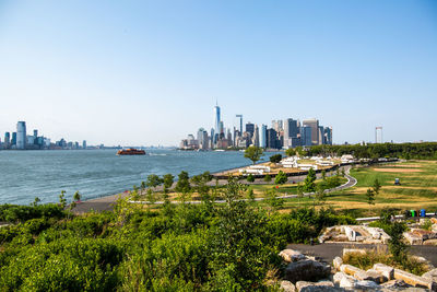 Scenic view of sea and buildings against clear sky