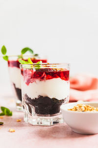 Cherry, cream cheese and chocolate biscuit portion layered dessert in glass. black forest trifle. 