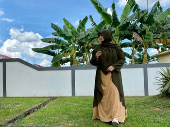 Full length of woman standing on field against sky