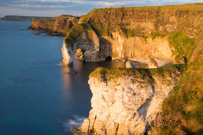 Rock formations by sea against sky