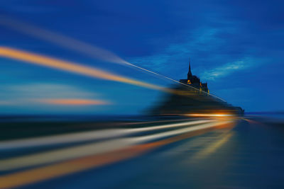 Blurred motion of light trails against sky at sunset