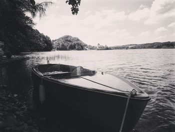 Boat moored in lake against sky