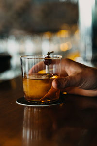 Midsection of woman drinking glass on table