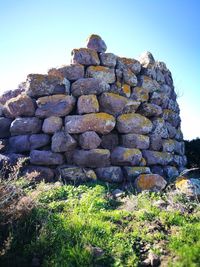 Stone wall on rock formation against clear sky