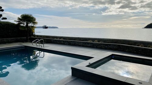 View of swimming pool by sea against sky