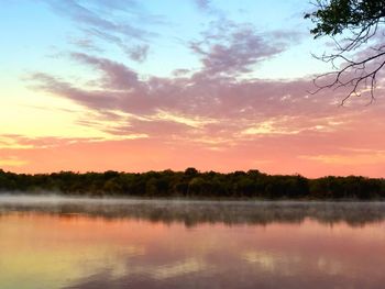 Scenic shot of calm countryside lake at sunset