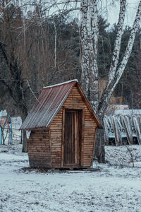 Snow covered houses by trees and building