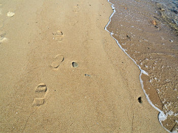 High angle view of footprints on wet sand