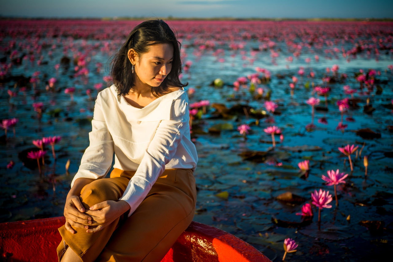 WOMAN SITTING WITH FLOWERS IN HAIR