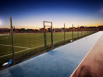 View of soccer field against clear sky during sunset