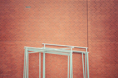 White metallic poles against red brick wall