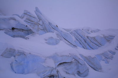 Snow covered landscape against sky