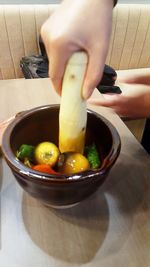 Close-up of person preparing food in bowl on table