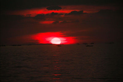 Scenic view of sea against dramatic sky during sunset