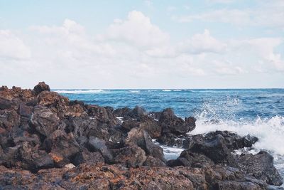 Rock formation in sea against sky