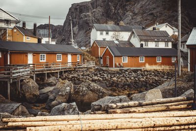 Houses by buildings against sky