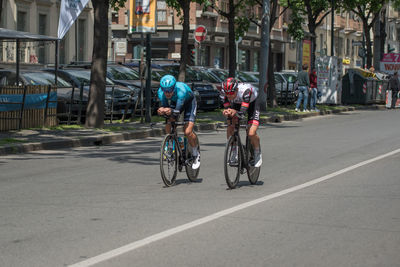 People riding bicycle on road in city