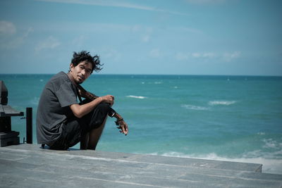 Young man with camera at the seaside