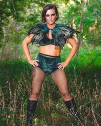 Portrait of woman standing on grass in forest